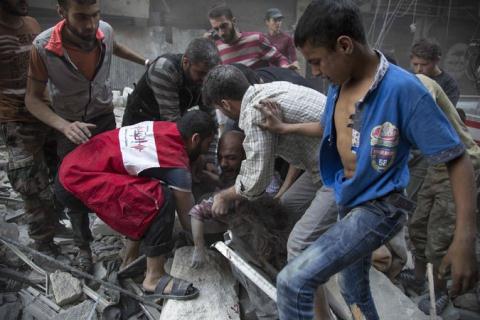 Người đàn ông khóc ôm cô con gái nhỏ bị vùi trong đống đổ nát sau trận bom tại Aleppo chiều thứ 3. Ảnh: The New York Times